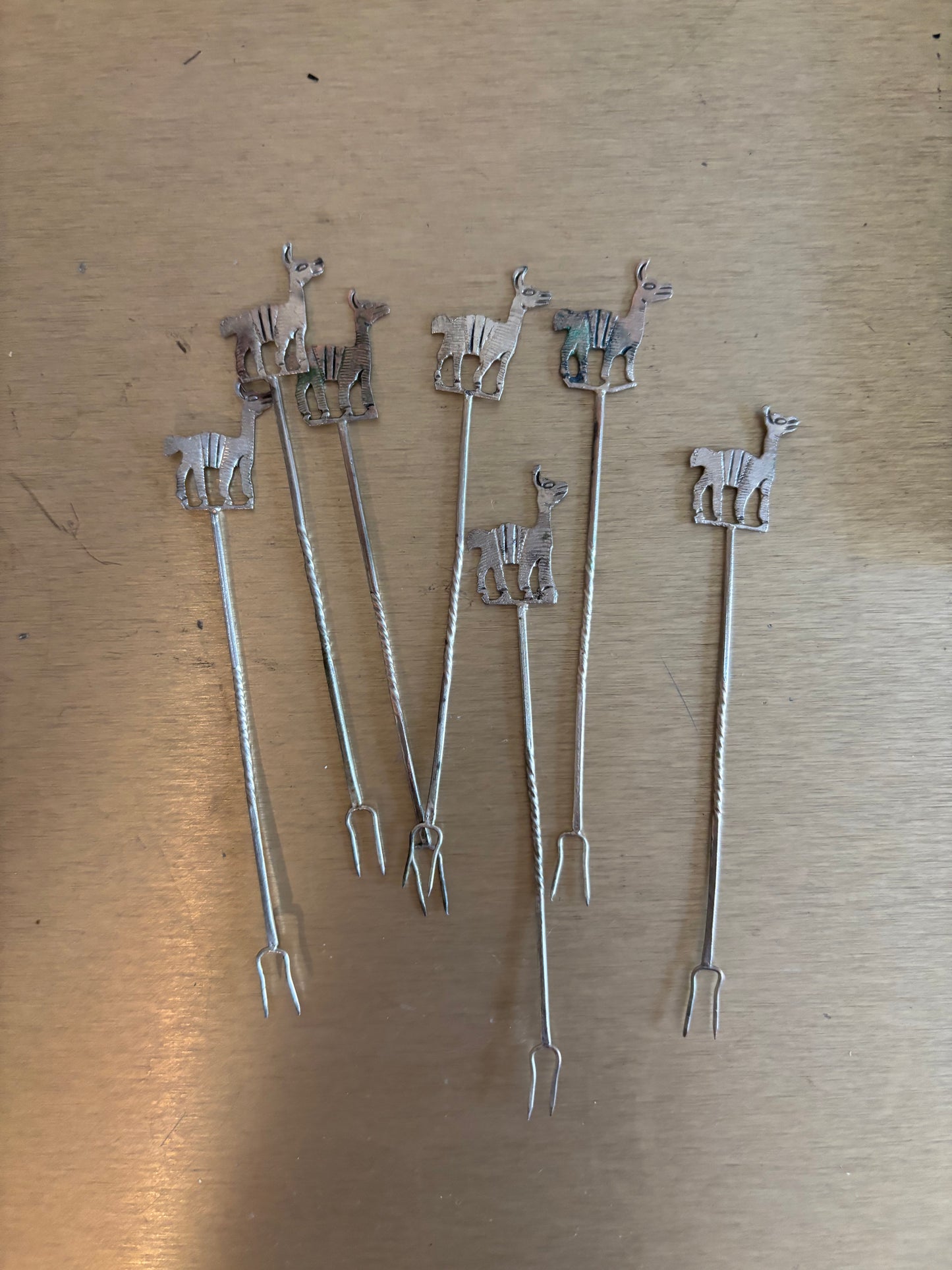 JUEGO DE 7 PINCHOS EN METAL CON FIGURAS DE ALPACAS.