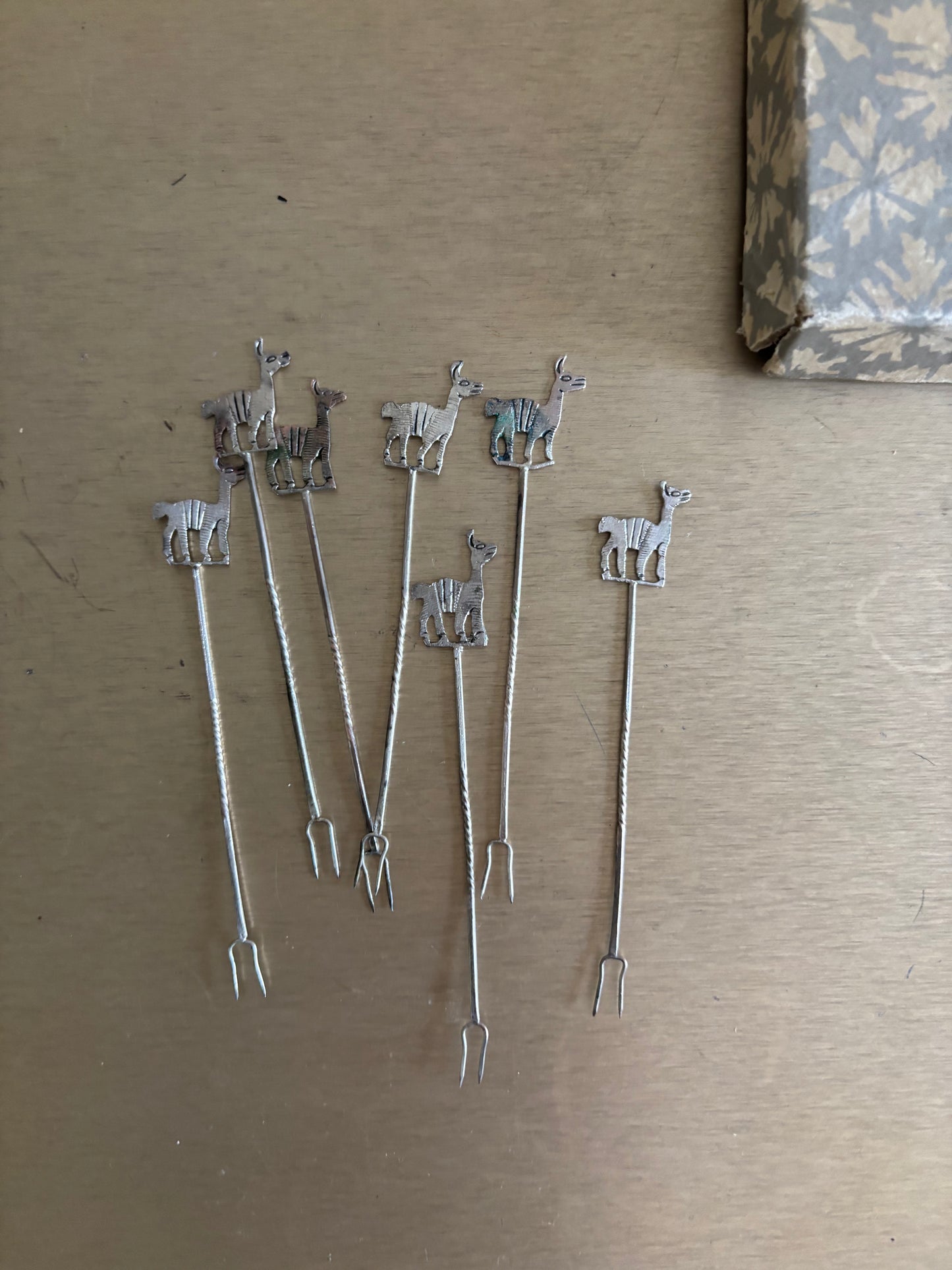 JUEGO DE 7 PINCHOS EN METAL CON FIGURAS DE ALPACAS.