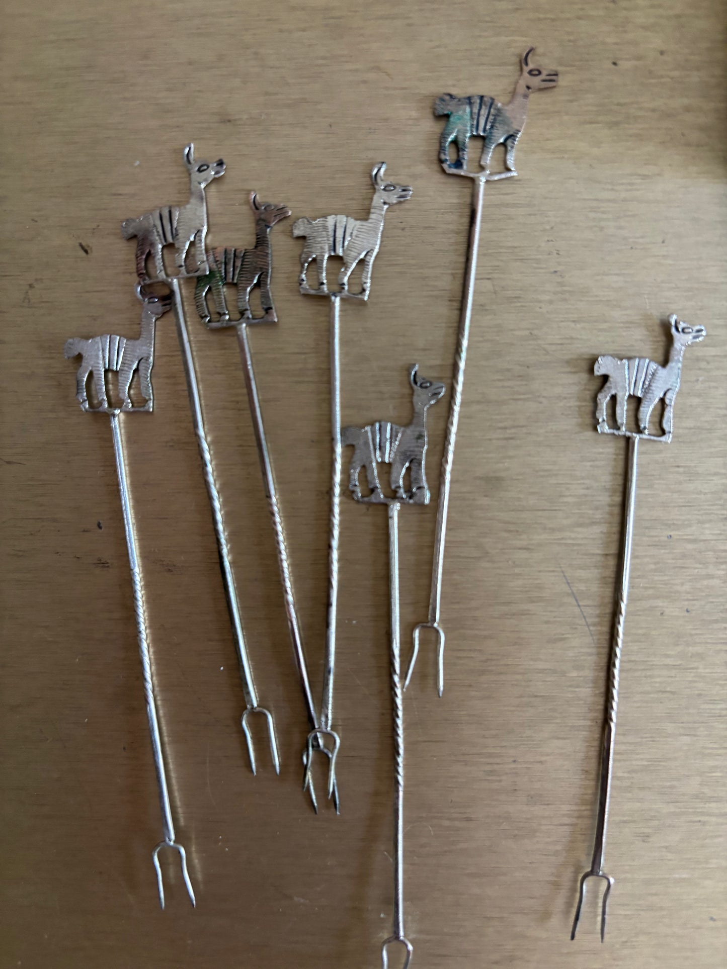 JUEGO DE 7 PINCHOS EN METAL CON FIGURAS DE ALPACAS.